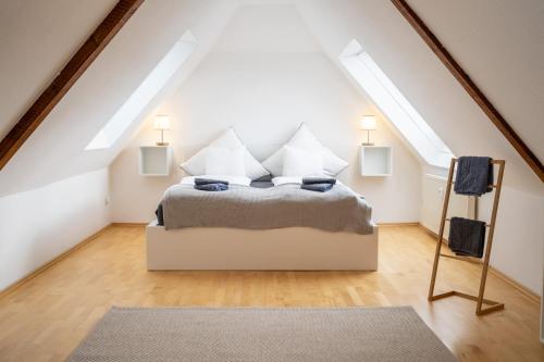 Schlafzimmer mit einem Bett im Dachgeschoss mit Oberlichtern in der Unterkunft Große 3-Zimmer Maisonette Wohnung in Neuhausen in Neuhausen