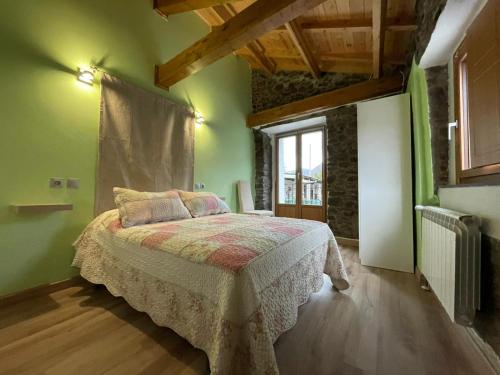 a bedroom with a bed in a room with green walls at Casa Osu Pardo VuT in Caboalles de Abajo