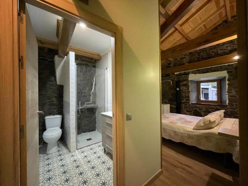 a bathroom with a bed and a toilet in a room at Casa Osu Pardo VuT in Caboalles de Abajo