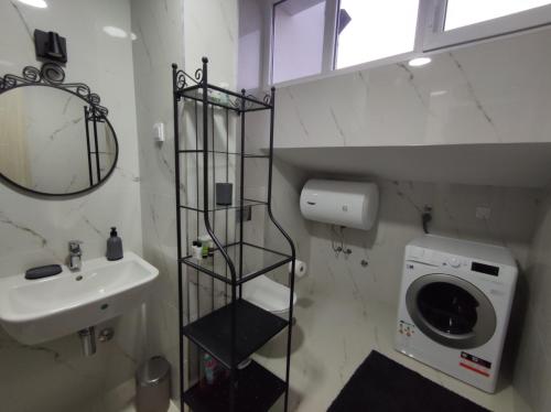 a bathroom with a washing machine and a sink at Blue Apartment Riverside in Podgorica