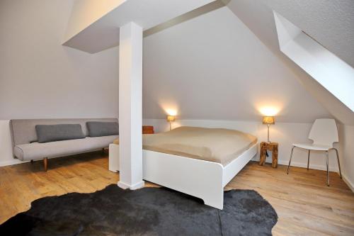 a white bedroom with a bed and a couch at Residenz unter den Linden Wohnung 27 in Kühlungsborn