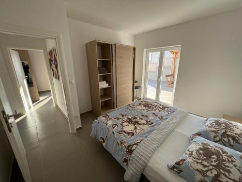 - une chambre avec un lit et une porte donnant sur un balcon dans l'établissement Villa Rubina**** Apartment Luca 140 qm, à Tisno