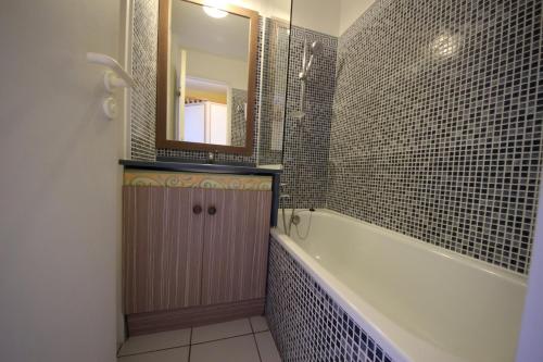 une salle de bain avec une baignoire, un lavabo et un miroir dans l'établissement Studio 5 people with beautiful sea view, à Drammont