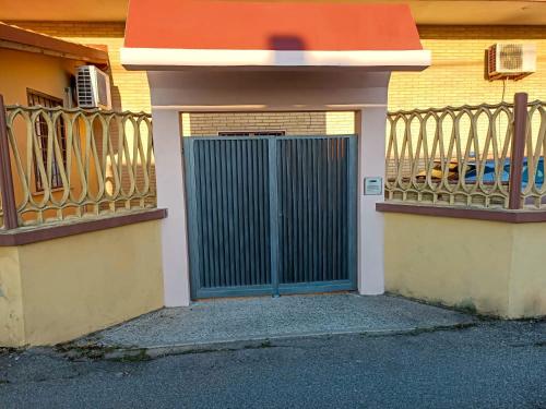 a gate in the side of a building with surfboards at Casa Malù in Fiumicino