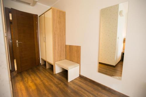 a hallway with a white stool in front of a mirror at Hotel Luna in Međugorje