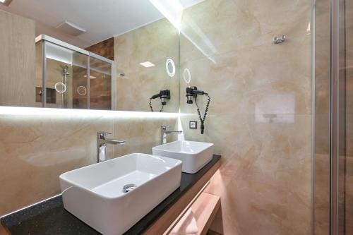 a bathroom with a white sink and a shower at Hotel Ludwigs in Füssen
