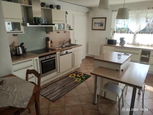 a kitchen with white cabinets and a table and a dining room at Ferienwohnung Mitwitz Kronach Neustadt Coburg - Erholung, Wandern uvm. sehr ruhig gelegen in Mitwitz