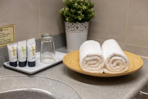 a plate with towels on a counter next to a sink at Logos hotel in Yad Hashmona in Yad Hashmona