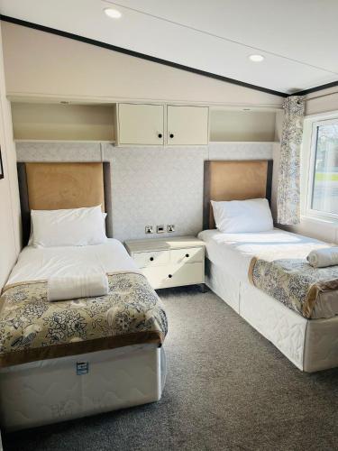 a bedroom with two beds and a window at Brackencroft Lodge with Hot Tub in York