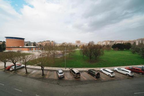 a parking lot with parked cars in a city at Sancho Ramirez in Pamplona