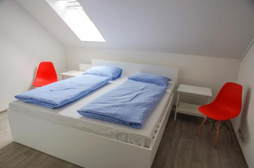 a bedroom with a bed and two red chairs at U Proroka in Bartošovice v Orlických Horách