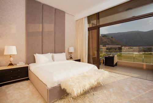 a bedroom with a large bed and a large window at Nameer Villas in Bandar Jişşah
