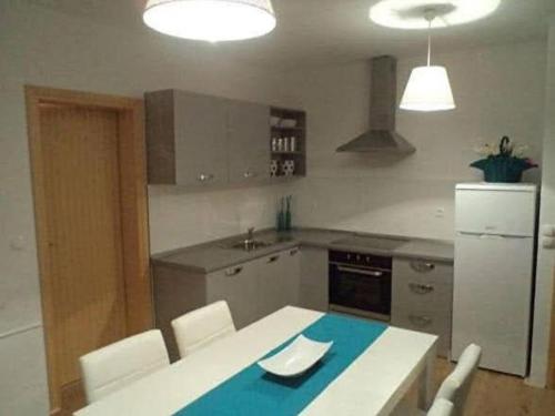 eine Küche mit einem weißen Tisch und Stühlen sowie einem weißen Kühlschrank in der Unterkunft Ugljanski gusari in Ugljan