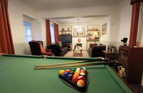 a living room with a pool table with cue balls at The Corner House - Historic Character Cottage in the Forest in Coleford