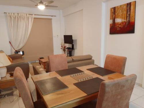 a dining room and living room with a table and a couch at Aphrodite Springs in Paphos City