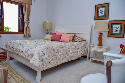 Schlafzimmer mit einem Bett mit rosa Kissen und einem Fenster in der Unterkunft Casa beira mar na Praia da Enseada no Guaruja SP in Guarujá