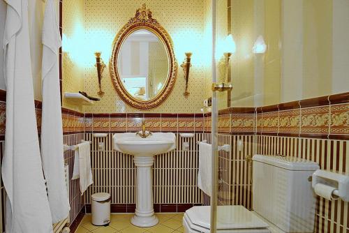 ein Badezimmer mit einem Waschbecken, einem WC und einem Spiegel in der Unterkunft Villa Laura Wohnung 01 in Kühlungsborn
