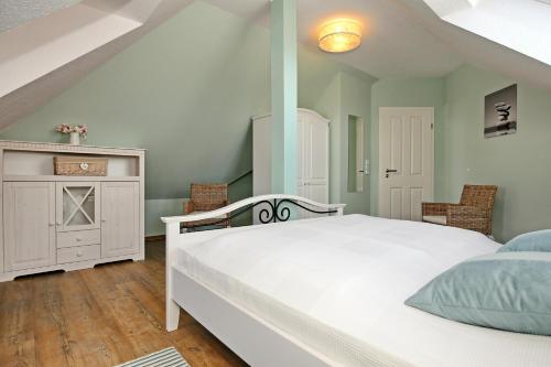 Villa Hanse Wohnung 320 في كولونغسبورن: غرفة نوم بسرير ابيض وخزانة