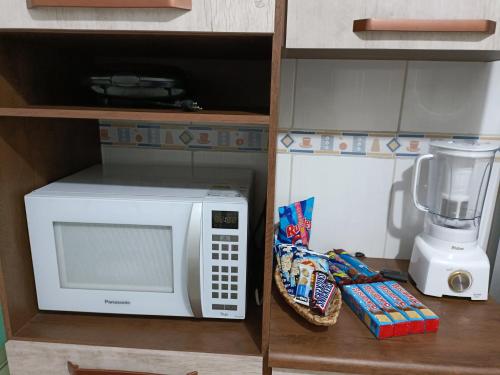 um balcão de cozinha com um micro-ondas e um liquidificador em 10 MIN AEROPORTO GUARULHOS em Guarulhos