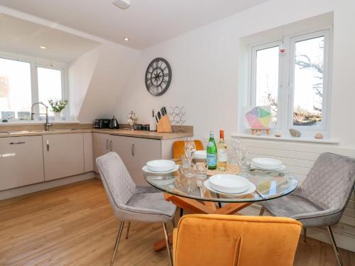 a kitchen and dining room with a table and chairs at Seaspray in Dartmouth