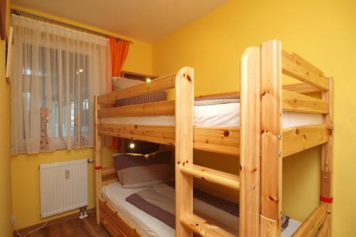 2 Etagenbetten in einem Zimmer mit gelben Wänden in der Unterkunft Meeresblick Wohnung 408 in Kühlungsborn