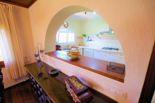 a kitchen with an archway over a wooden counter at V&V LLORET- VILLA ELSA, lujosa y exclusiva villa para 10-11PAX con 2 piscinas INTERIOR Y EXTERIOR y gran jardín con césped natural in Lloret de Mar