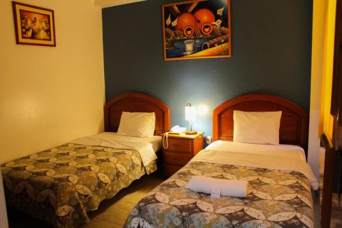 a bedroom with two beds and a picture on the wall at Hotel Costa Norte in Chiclayo