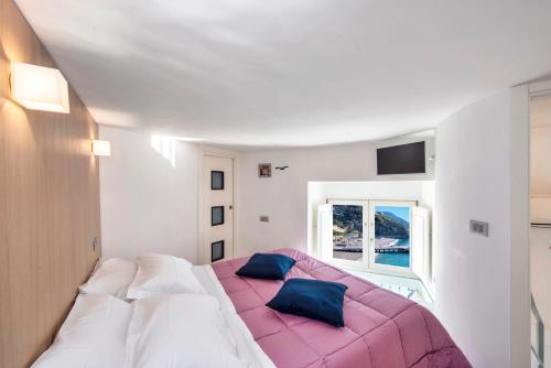 a bedroom with a large bed with a pink blanket at IL Nido Del Gabbiano in Minori
