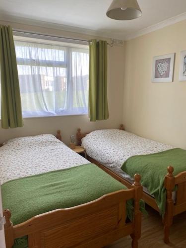 1 dormitorio con 2 camas individuales y ventana en Brambles chine, en Freshwater