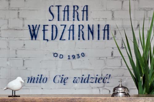 un pájaro blanco sentado en una mesa frente a un cartel en Kurort Stara Wędzarnia en Gdansk
