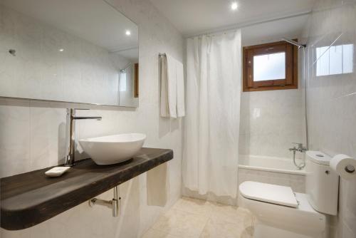 a white bathroom with a sink and a toilet at Hostal Kimboa in Ansó