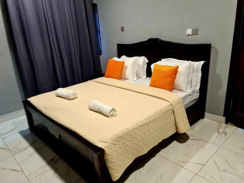 Pantang的住宿－Comfy & Cozy Hideout Close to Highway Parking，一间卧室配有带橙色和白色枕头的床