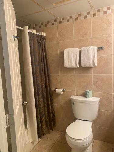 a bathroom with a toilet and a shower with towels at River Place Condos #101 2BD in Pigeon Forge