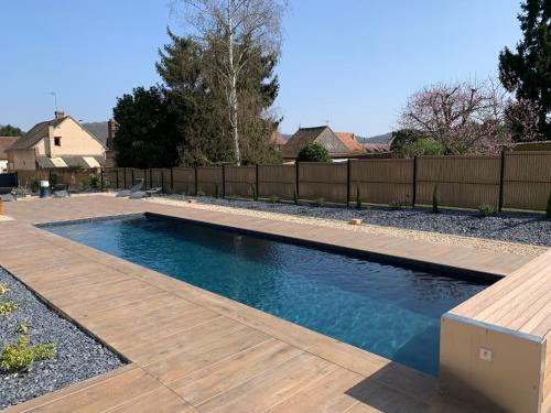 a swimming pool in a backyard with a wooden fence at L'Hostellerie d'Acquigny in Acquigny