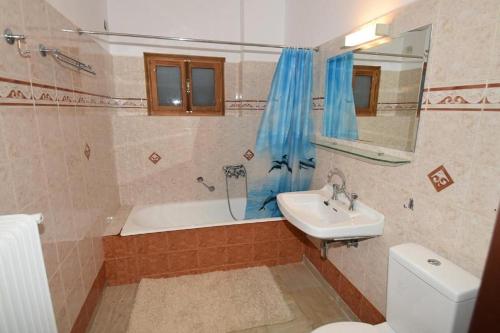 a bathroom with a tub and a sink and a toilet at Villa Erika Mountain Escape in Áno Vlasía