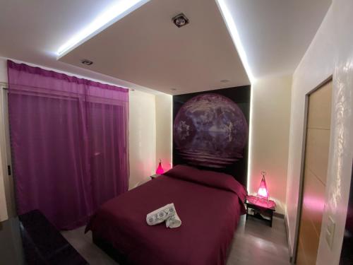 Un dormitorio con una cama púrpura con dos zapatos. en Résidence Les Eucalyptus, en Antibes