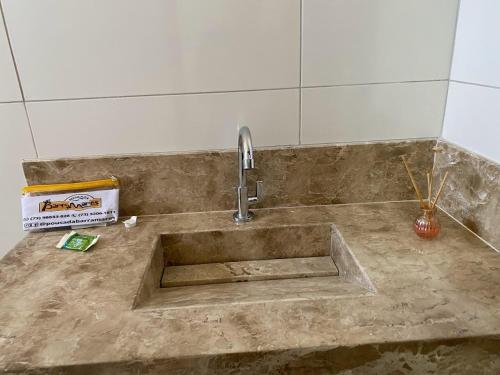 a kitchen sink with a faucet on a counter at Pousada Barra Mares in Mucuri