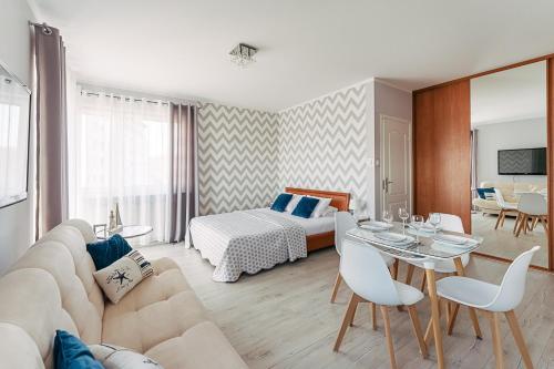 a living room with a couch and a bed at CHILLIapartamenty - Portowa - SAILOR in Kołobrzeg