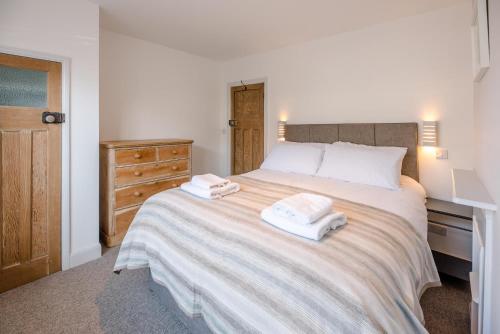 a bedroom with a large bed with towels on it at Swifts in Southwold