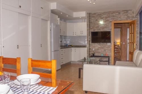 マラガにあるMalagueta, Primera Linea de Playaのキッチン、リビングルーム(テーブル、椅子付)