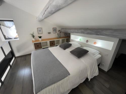 a bedroom with a large white bed with two pillows at Gîtes dans Mas en pierres in Robion en Luberon