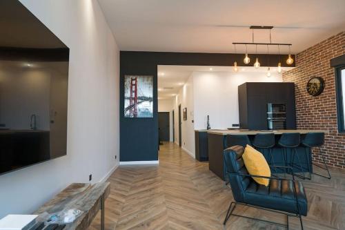 une cuisine et un salon avec une chaise bleue et un comptoir dans l'établissement Appartement d’exception en centre ville sur quai, à Sète
