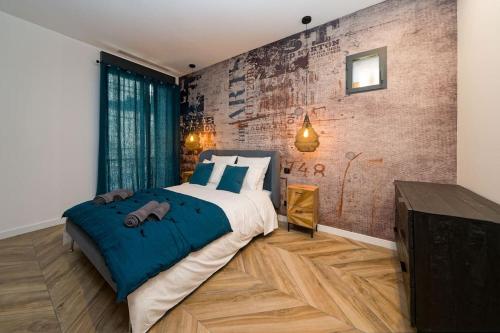 une chambre avec un grand lit et un mur de briques dans l'établissement Appartement d’exception en centre ville sur quai, à Sète