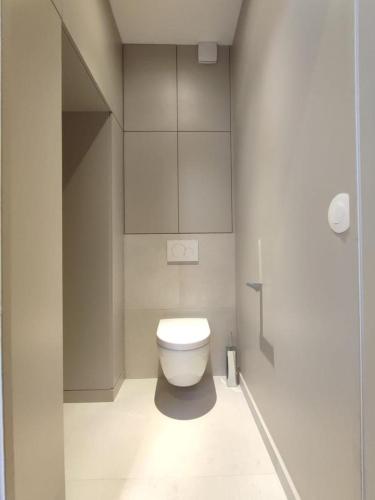 une salle de bain avec des toilettes blanches dans une chambre dans l'établissement Suite confortable sur le canal Saint-Martin / République, à Paris