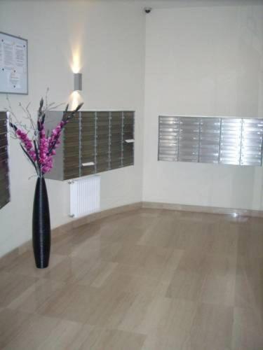 a room with a black vase with flowers in it at Most City Apart-Hotel in Dnipro