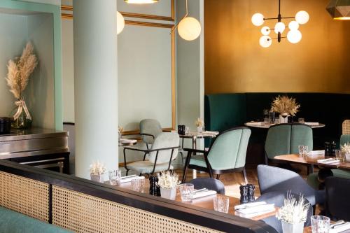 uma sala de jantar com mesas e cadeiras e um espelho em Demeures de Campagne Domaine de Maffliers - L'Isle-Adam em Maffliers