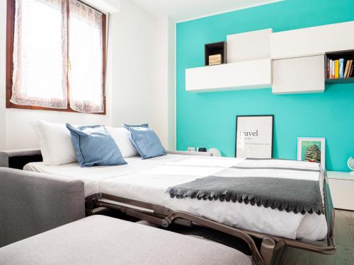 - une chambre avec un grand lit aux murs bleus dans l'établissement The Best Rent - Apartment near Arco della Pace, à Milan