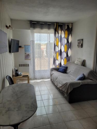 une chambre avec un lit, une table et une fenêtre dans l'établissement Location résidence Océane, à Soulac-sur-Mer