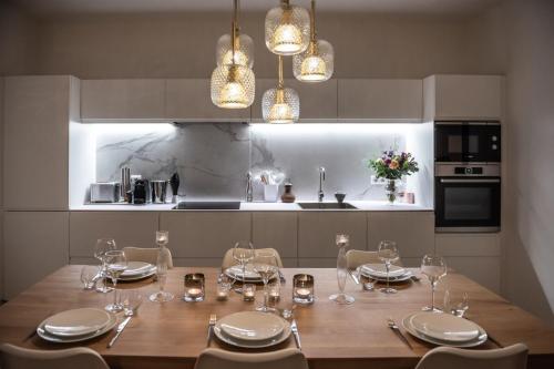 - une cuisine avec une table en bois et des verres à vin dans l'établissement Luxurious private garage apartment in the heart of Annecy, à Annecy