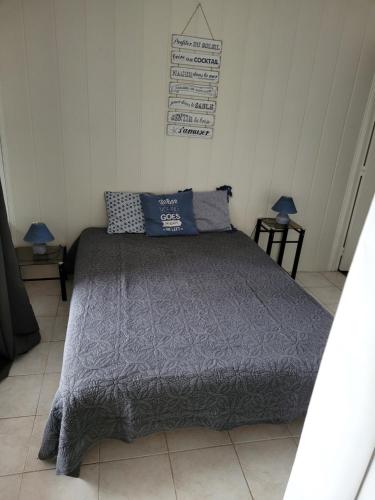 1 cama en un dormitorio con 2 lámparas y 2 almohadas en Location résidence Océane en Soulac-sur-Mer